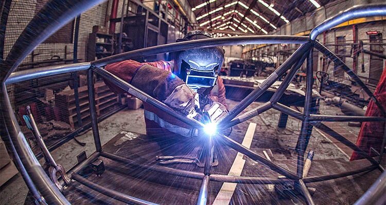 Welder fabricating tubular steel frame