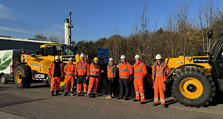 Hargreaves workers standing in front of heavy plant on a road