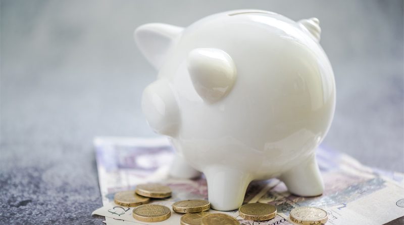 Piggy bank on top of English money to support UK pension article