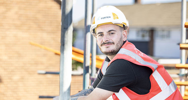 a construction worker wearing a hard hat with the logo "FORTEM" and a high-visibility vest