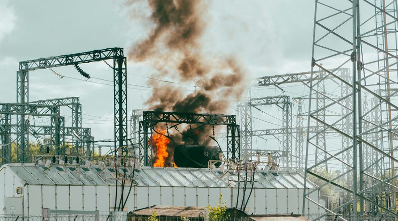 A fire-damaged electrical substation near Heathrow Airport, surrounded by emergency response vehicles