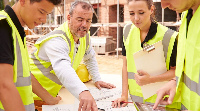 construction workers gathered around training desk