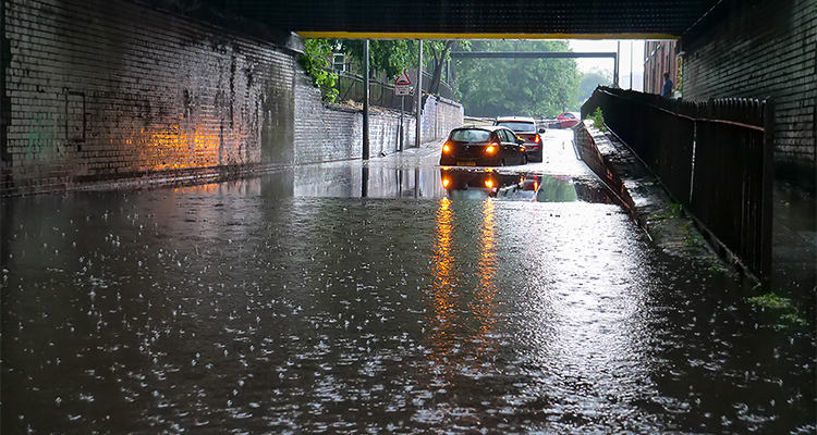Two cars stranded in flood water under low bridge in Salford