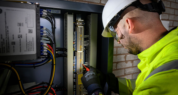 an electrician or technician working on an electrical panel.