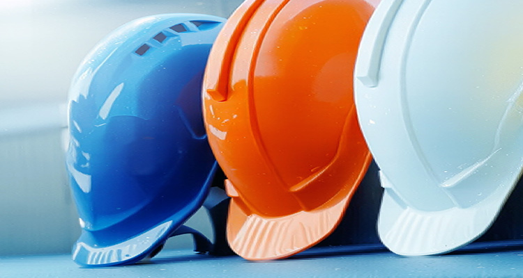 three protective safety helmets in blue, orange, and white colors