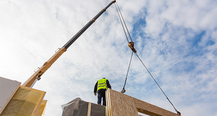 Roofer builder worker with crane installing structural Insulated Panels SIP. Building new frame energy-efficient house