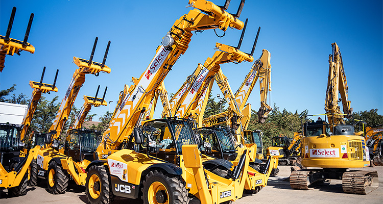 a fleet of yellow heavy construction machinery, primarily JCB telehandlers, parked outdoors on a bright, sunny day.