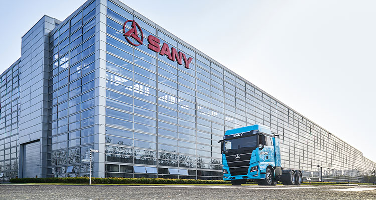 a Sany electric heavy truck in front of a Sany factory building