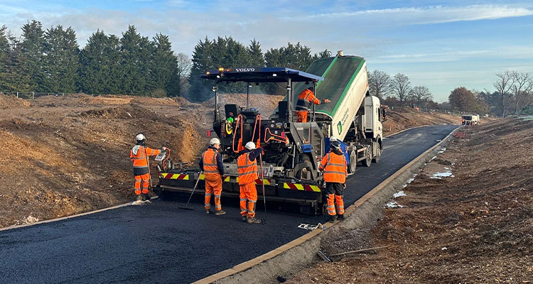 a crew performing road surfacing work using heavy machinery